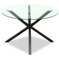 Round glass dining table by Hill Interiors with sleek metal legs, perfect for modern dining rooms.