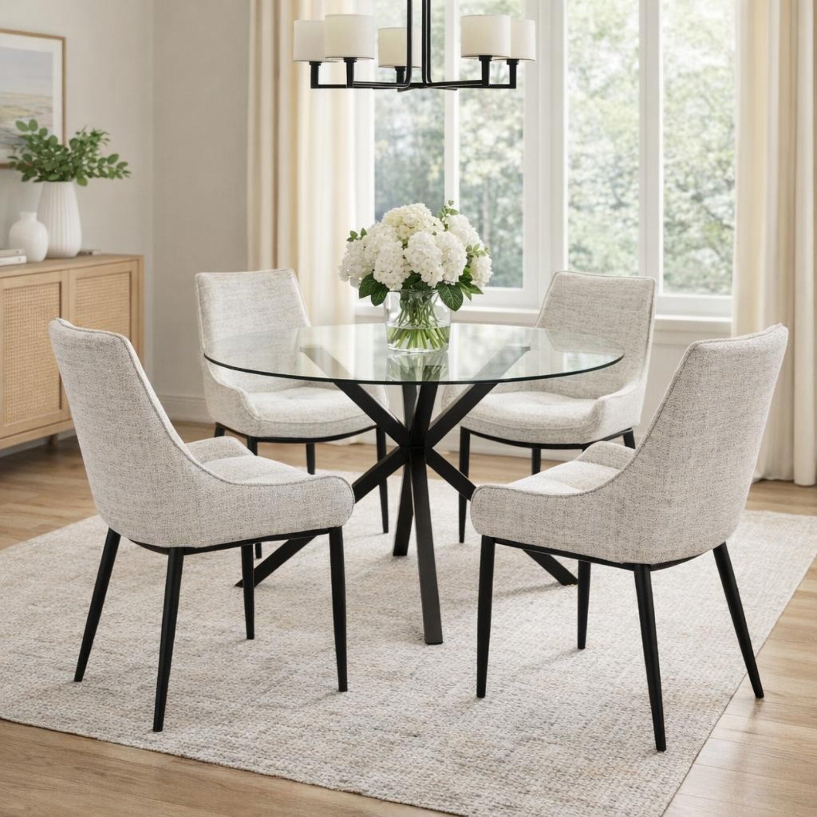 Round glass dining table by Hill Interiors with a sleek design, perfect for modern dining rooms.