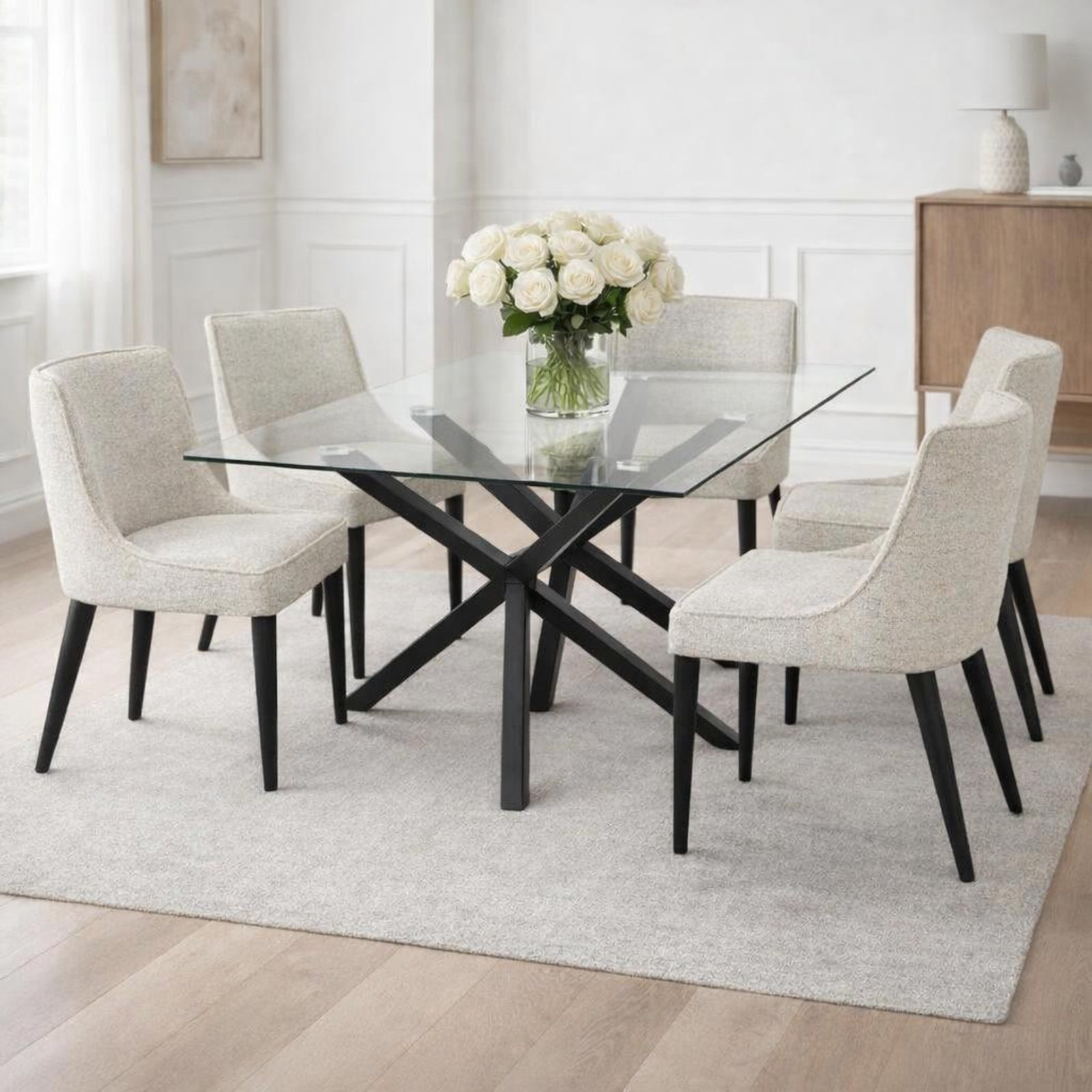 Rectangular glass dining table from Hill Interiors Monza collection, showcasing a modern, sleek design with clear glass top and sturdy base.