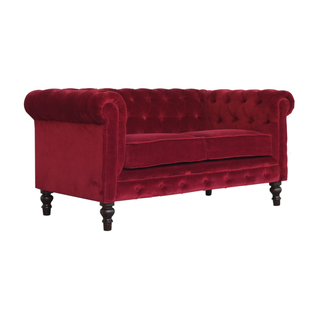 Artisan velvet Chesterfield sofa with tufted upholstery and rolled arms, showcasing luxurious design and rich fabric.