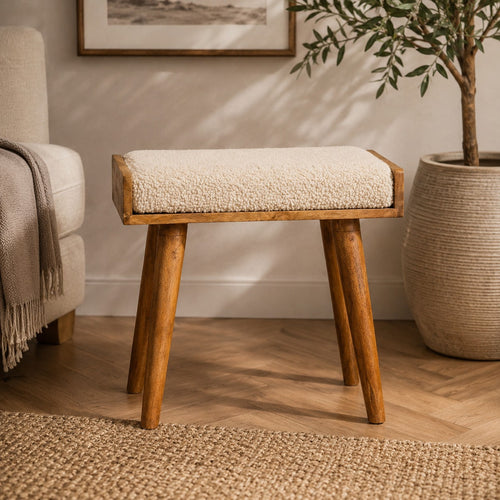 Artisan boucle cream tray style footstool with a plush upholstered seat and wooden legs, showcasing elegant and comfortable design.