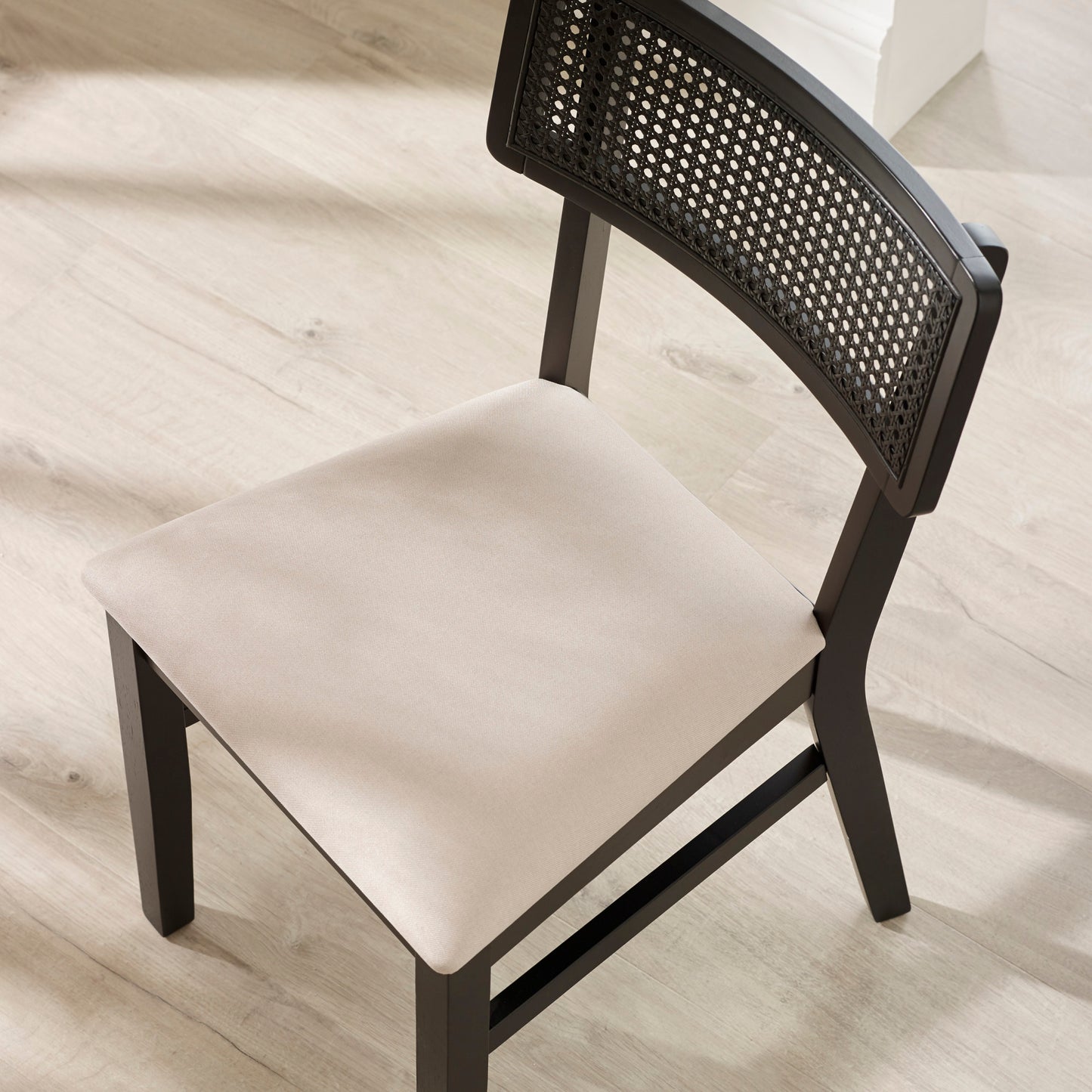 Rear angle view showing the sturdy wooden frame and woven back detail of the Annika dining chair