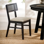 Annika black wooden dining chair with woven rattan backrest and natural fabric seat styled next to a black dining table