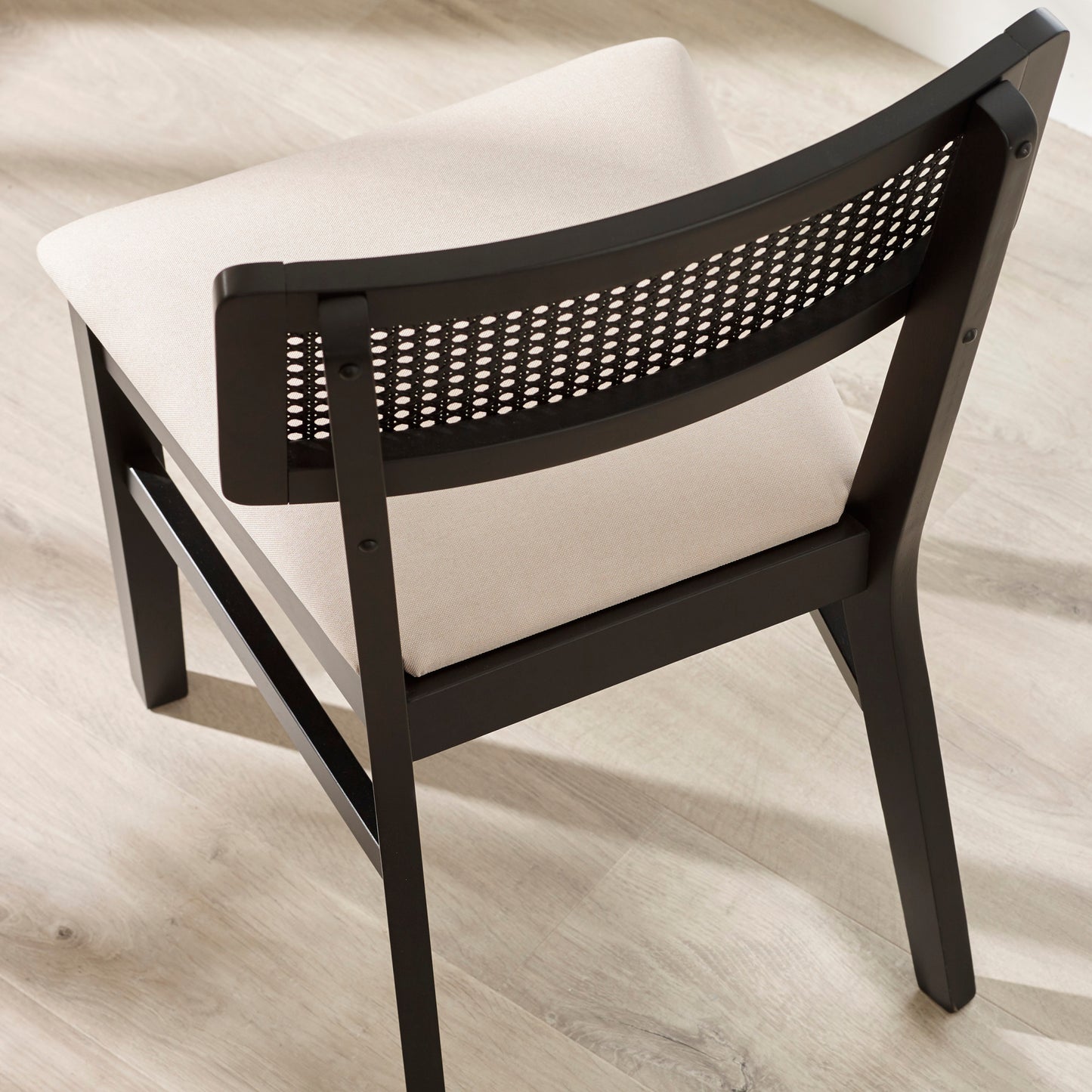High angle studio shot displaying the neutral upholstered seat cushion of the Annika black dining chair