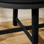 Close-up view of the sturdy wooden cross-stretcher base frame on the Annika black table