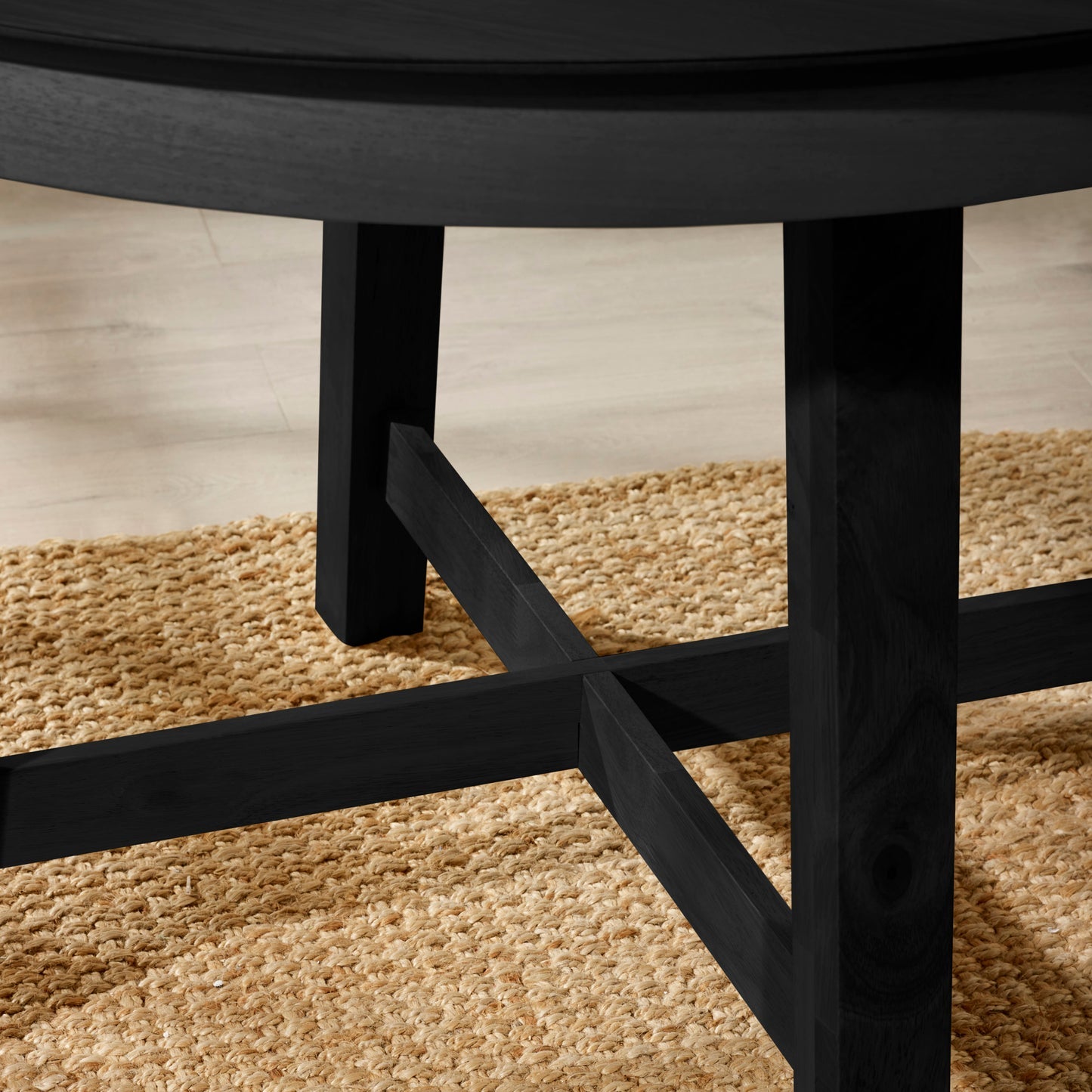 Close-up view of the sturdy wooden cross-stretcher base frame on the Annika black table