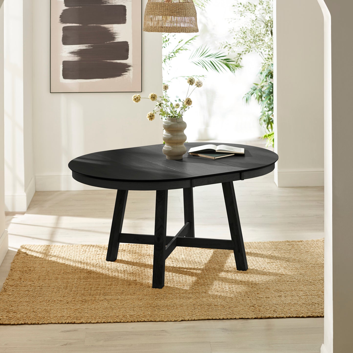 Perspective view of the Annika black dining table fully extended into an oval shape