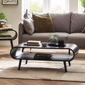 Apollo black curved wooden coffee table styled with books and decor in front of a grey sofa on a neutral rug