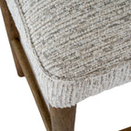 Macro shot showing the padded seat cushion texture and solid light wooden leg joinery.