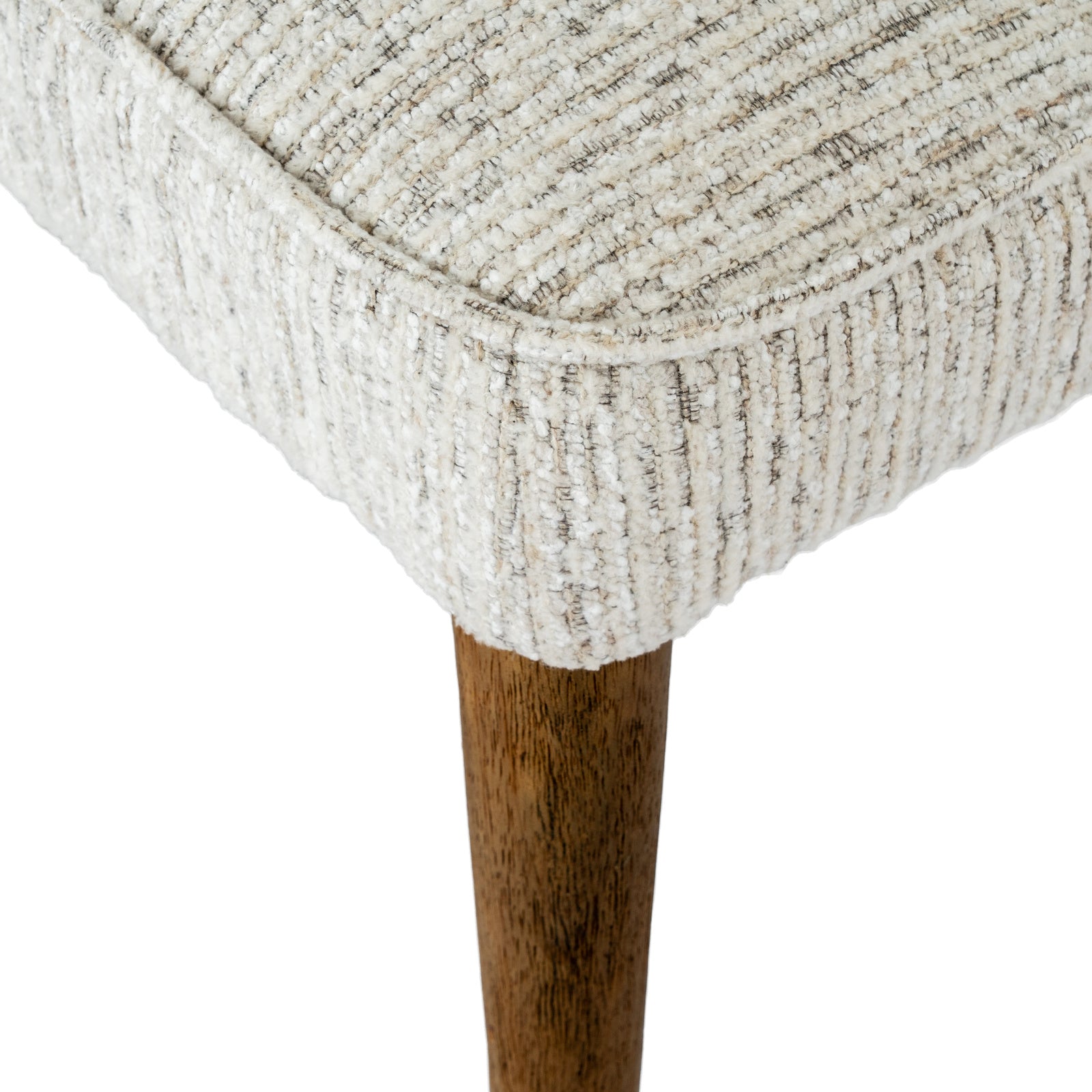 Detailed shot of the piping seam edge and warm wood-finish leg attachment on the Avia Mist dining chair