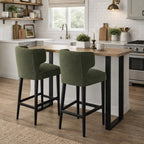 Pair of Avia Moss Upholstered Barstools with dark legs placed at a kitchen island breakfast bar.