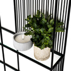 Close-up detail of the black metal geometric joint and clear tempered glass shelf edge.