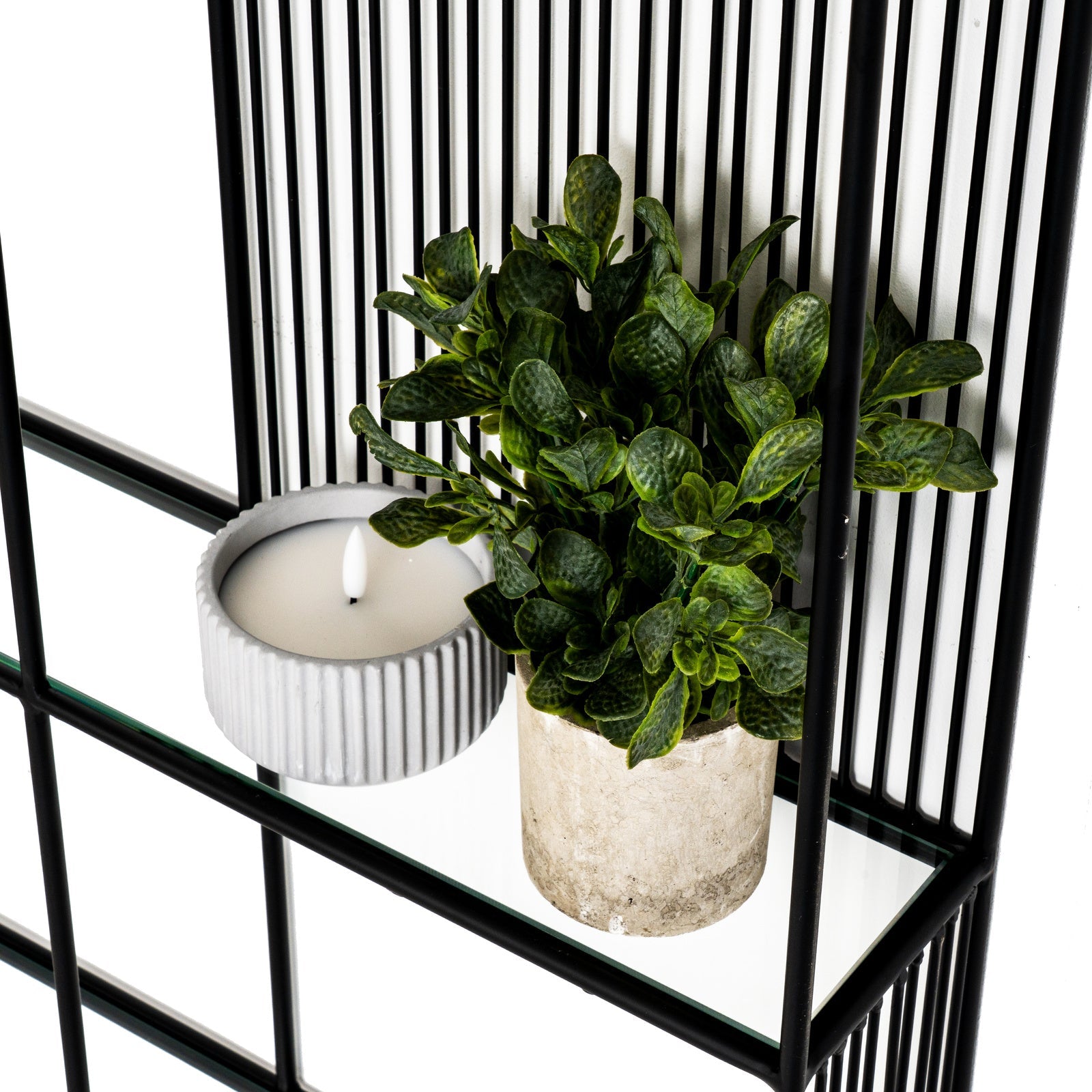 Close-up detail of the black metal geometric joint and clear tempered glass shelf edge.