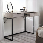 Bali grey oak effect 2 drawer dressing table desk styled with a mirror and cosmetics next to a bed