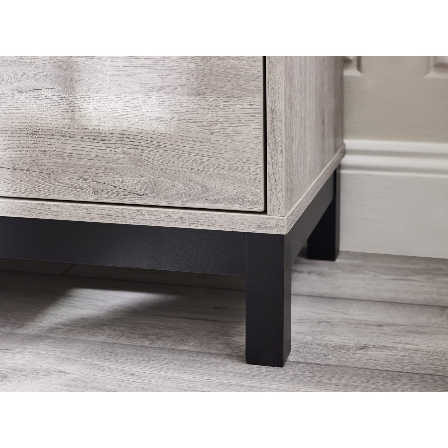 Detail shot showing the black metal frame leg and lower border on the Bali grey oak chest