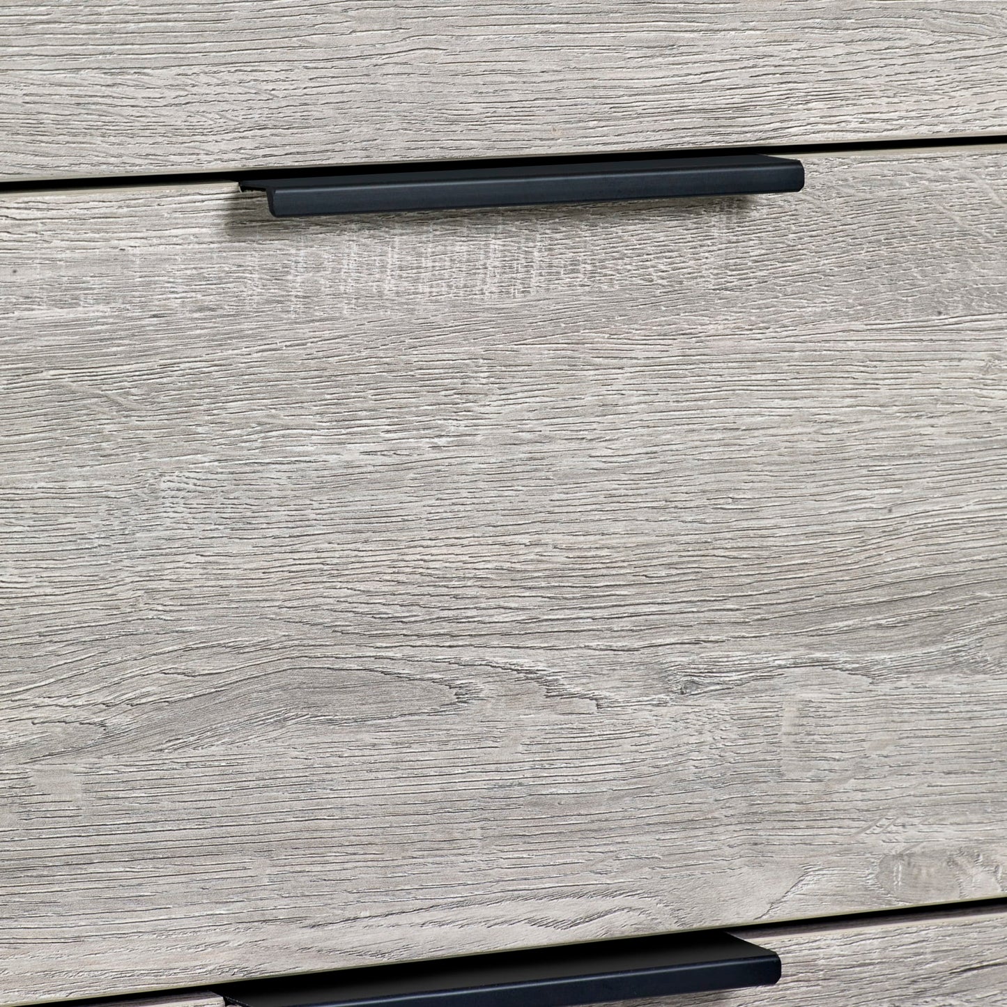 Detail shot of the grey oak drawer front and black lip pull handle on the Bali 4 drawer chest