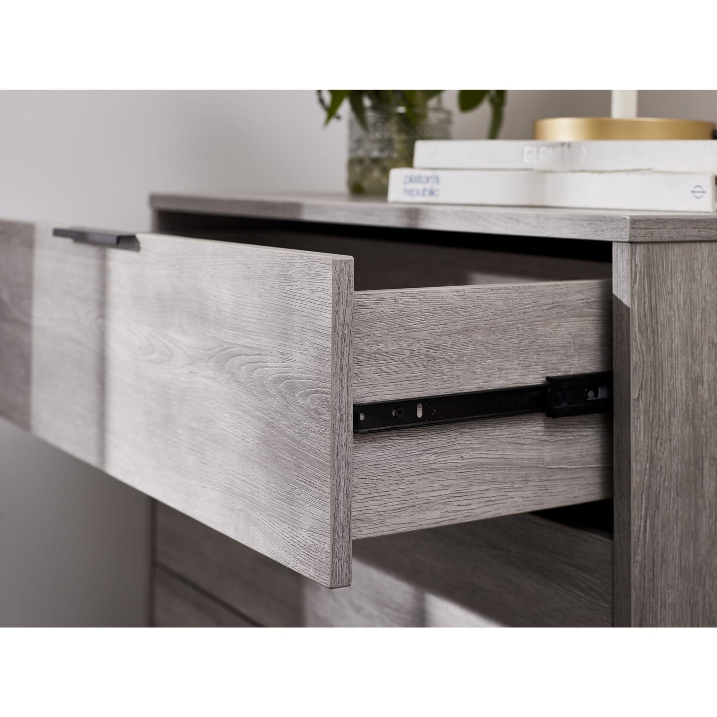 Close-up view of an open drawer displaying the internal depth and metal drawer runner on the Bali grey chest