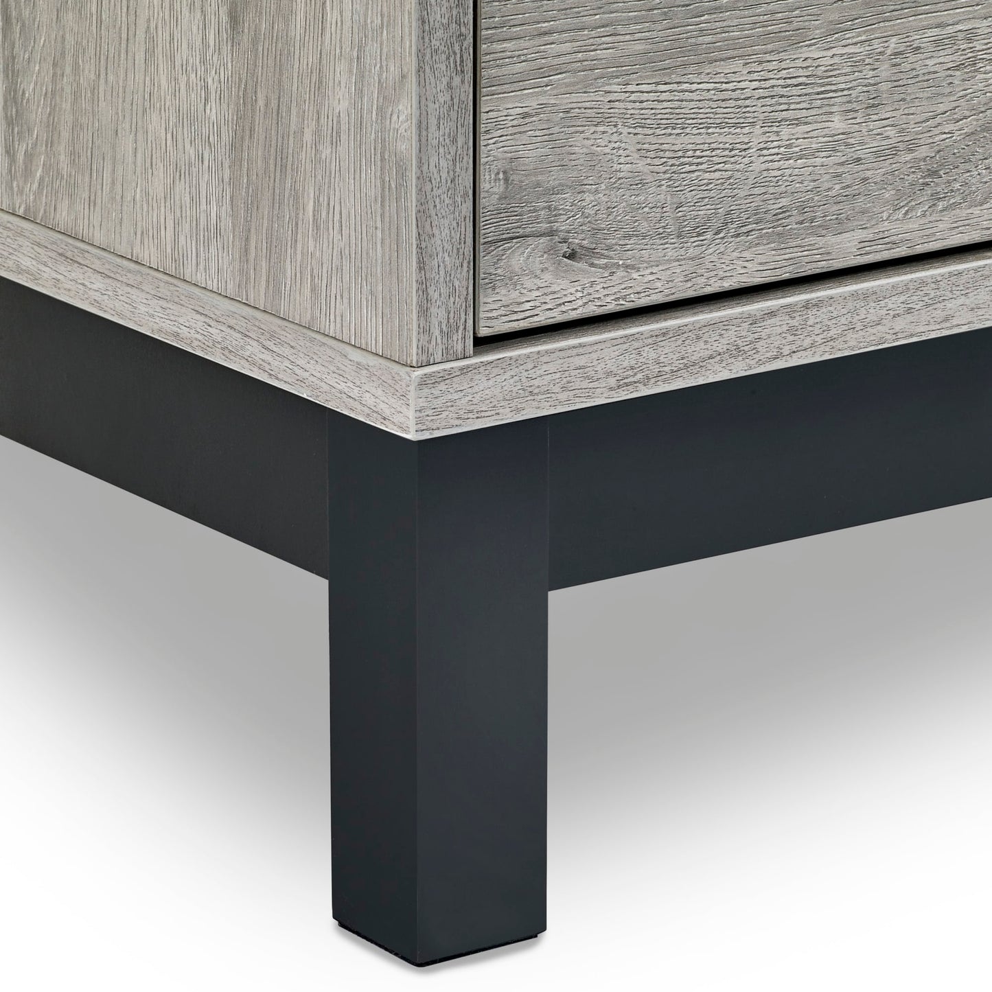 Close-up view of the black metal leg and lower frame border on the Bali grey oak chest of drawers