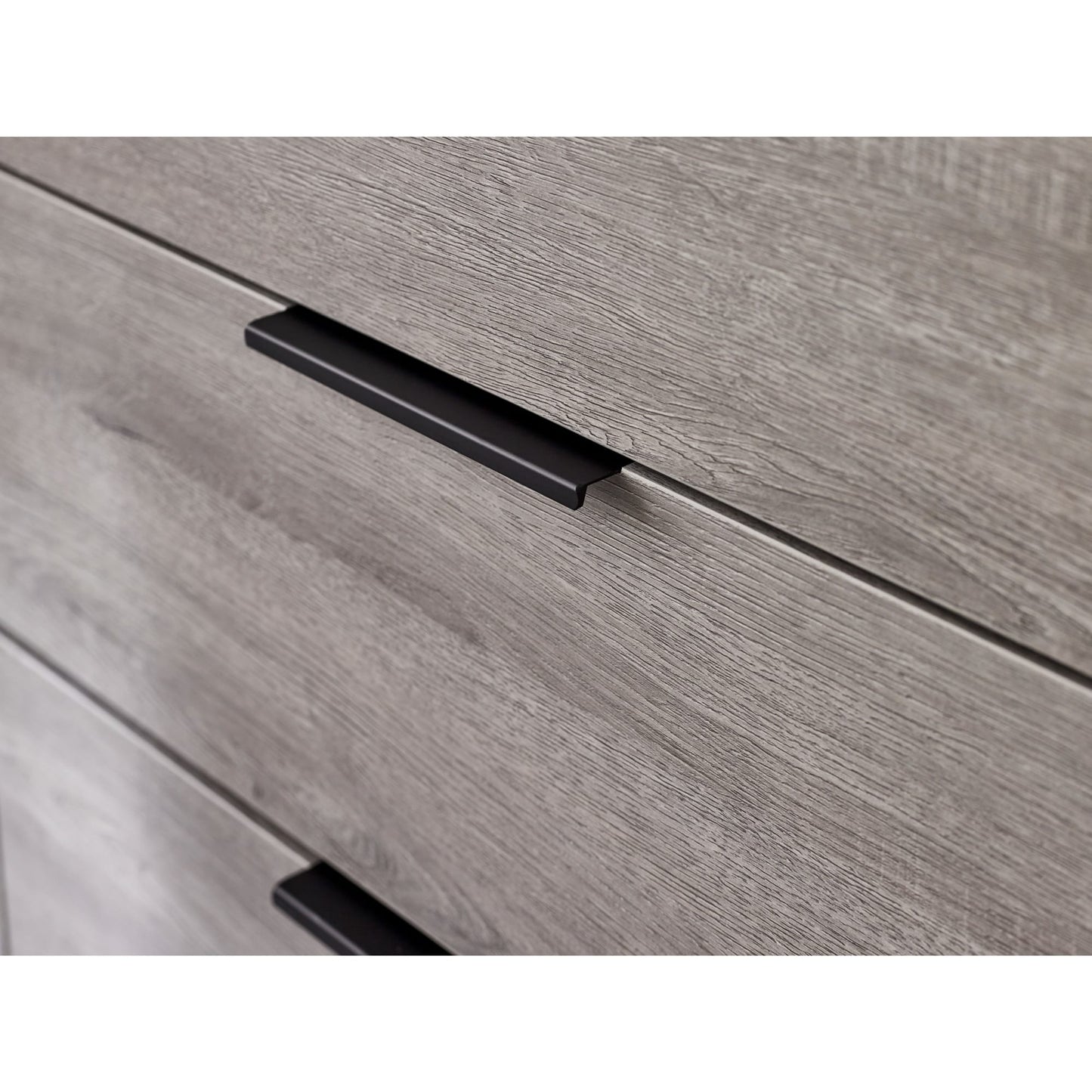 Close-up view of the grey oak wood effect texture and slim black metal lip drawer handle on the Bali chest