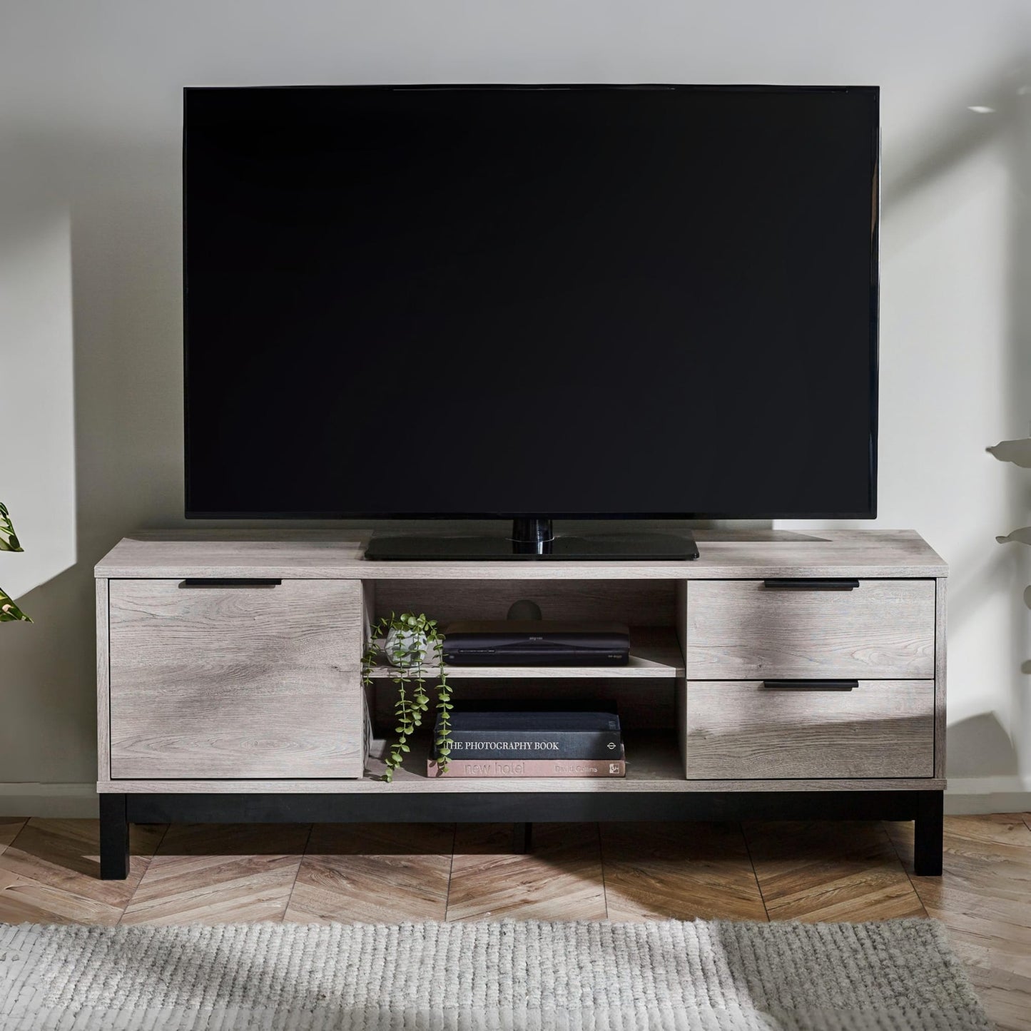 Bali grey oak effect TV unit styled with a television and decor in a contemporary living room space