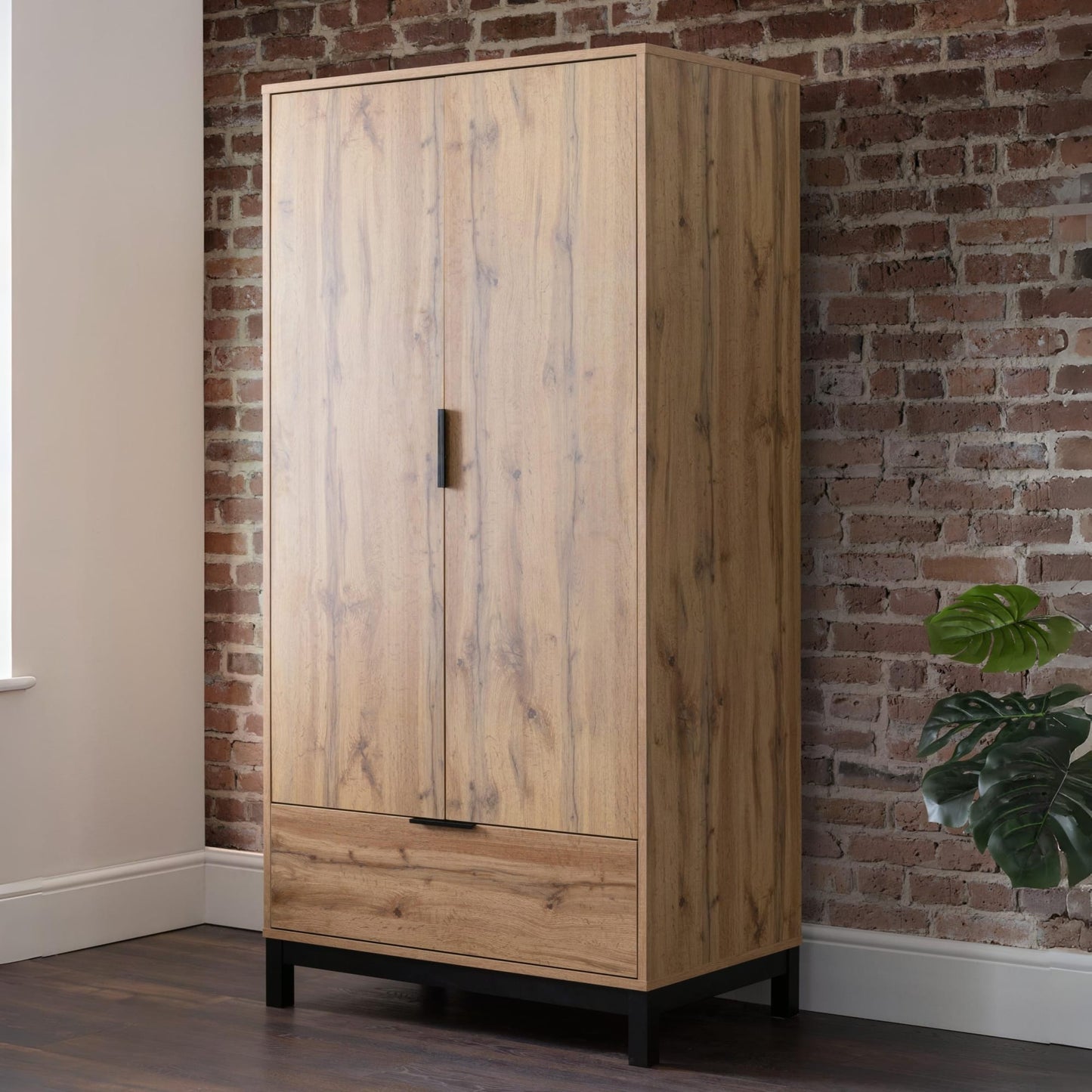 Bali natural oak effect 2 door 1 drawer wardrobe styled against a brick wall in a modern industrial bedroom