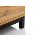 Detail view of the black metal underframe leg support on the Bali natural oak 4 drawer chest