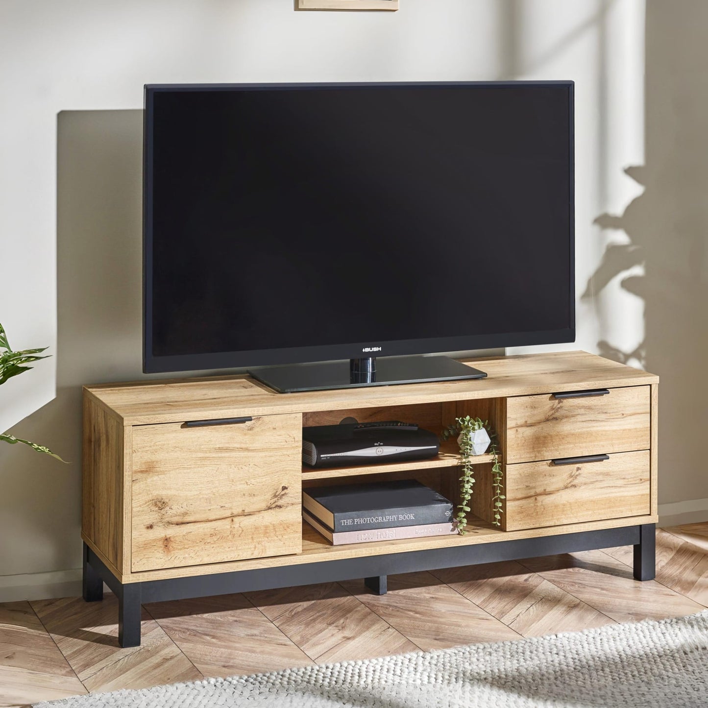 Bali natural oak effect TV unit styled with a flat-screen television, books, and media console in a living room