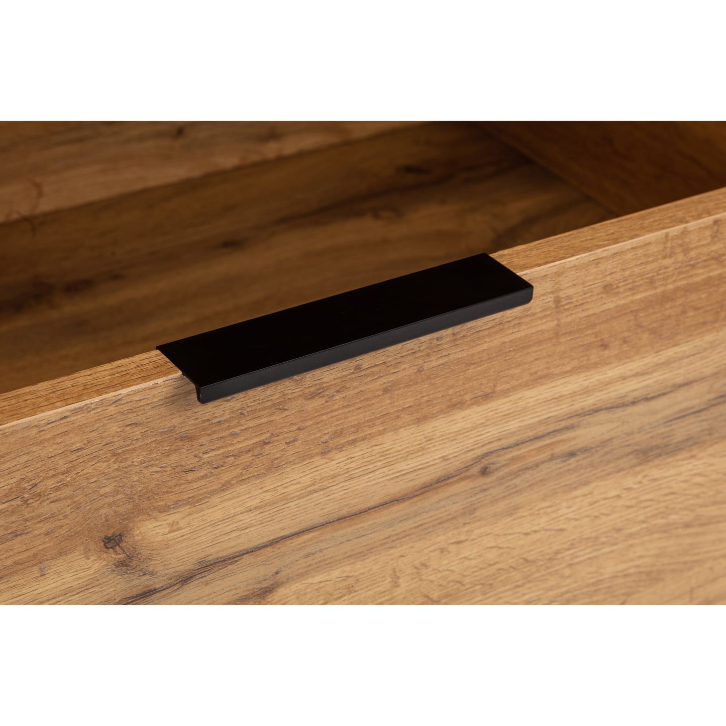 Detail view of the lower drawer front and black metal lip pull handle on the Bali oak wardrobe