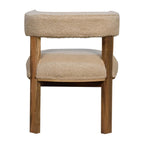 Close-up detail showing the soft cream bouclé upholstery texture against the smooth solid wood armrest.