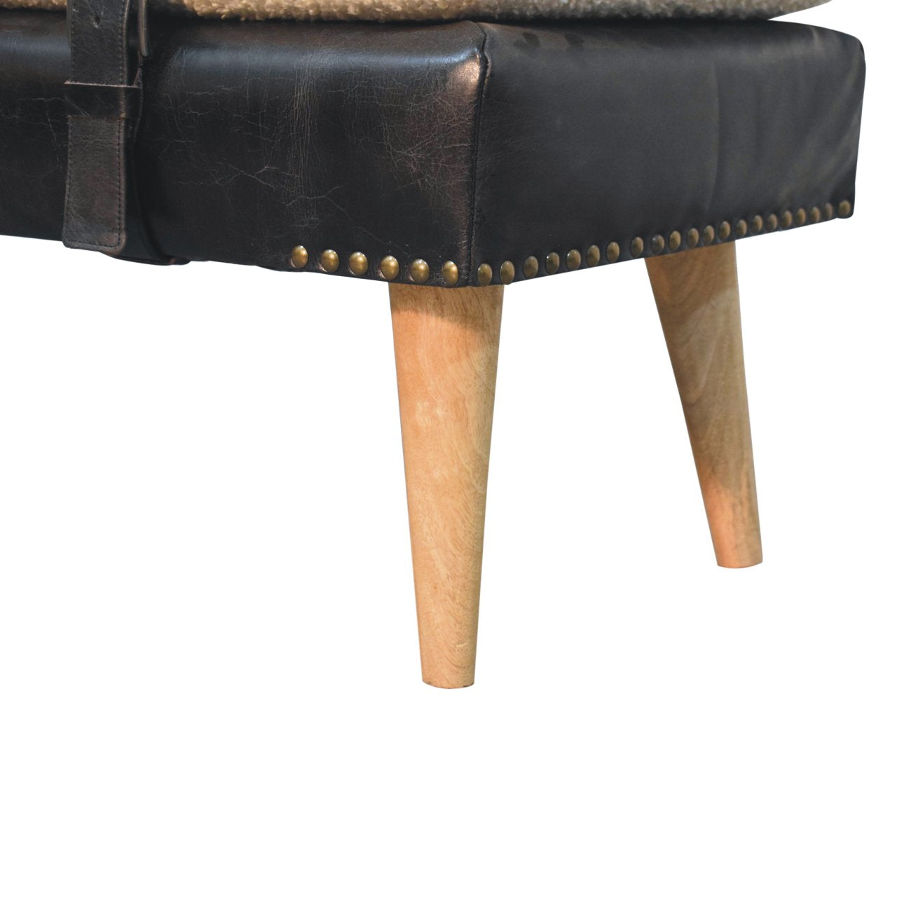 Macro shot of the black leather base with metal stud accents and natural wooden legs.