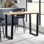 Dining table with black legs and a wooden top in a modern kitchen setting.