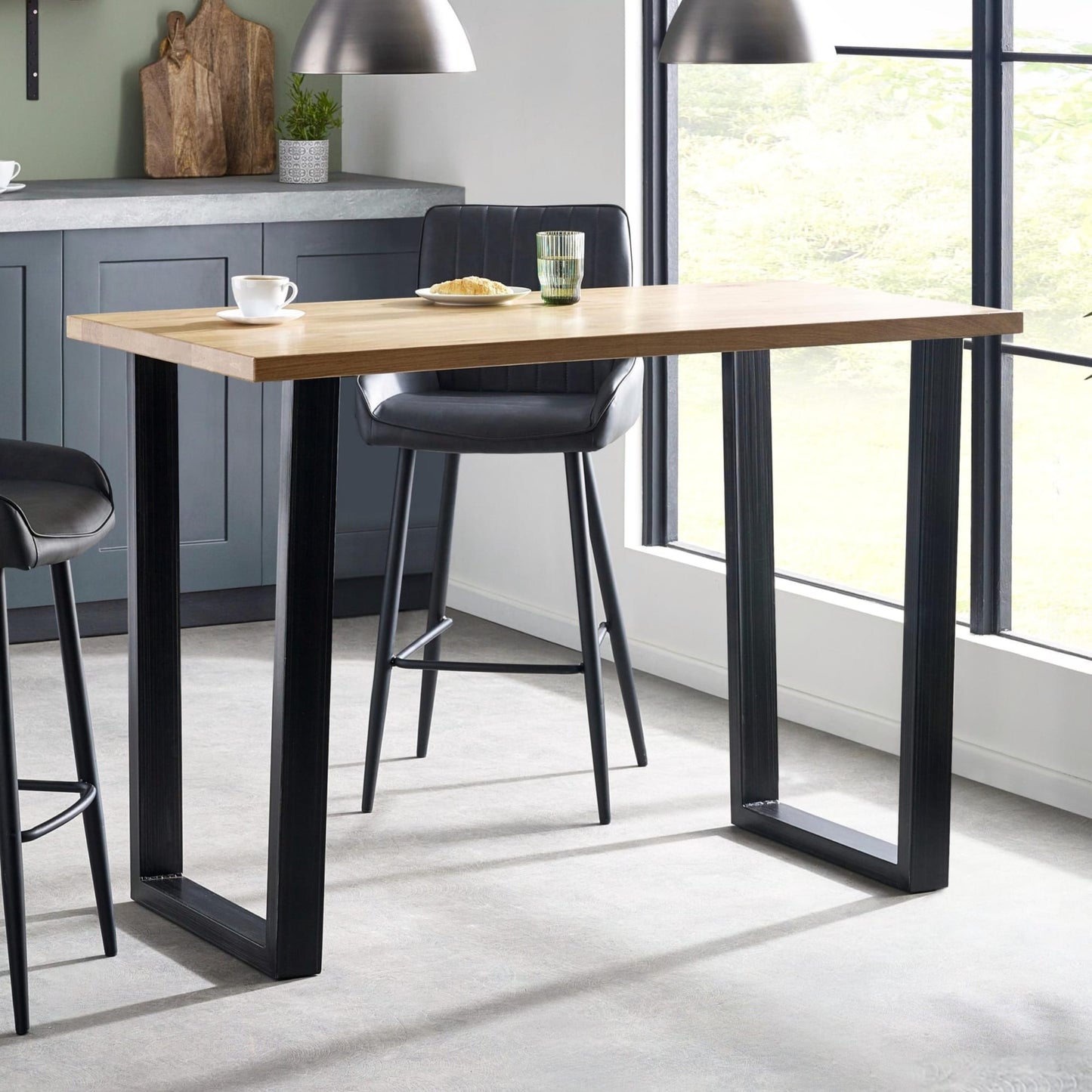 Dining table with black legs and a wooden top in a modern kitchen setting.