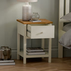 Close-up detail of the painted ivory drawer front, matching knob, and classic oak top surface.