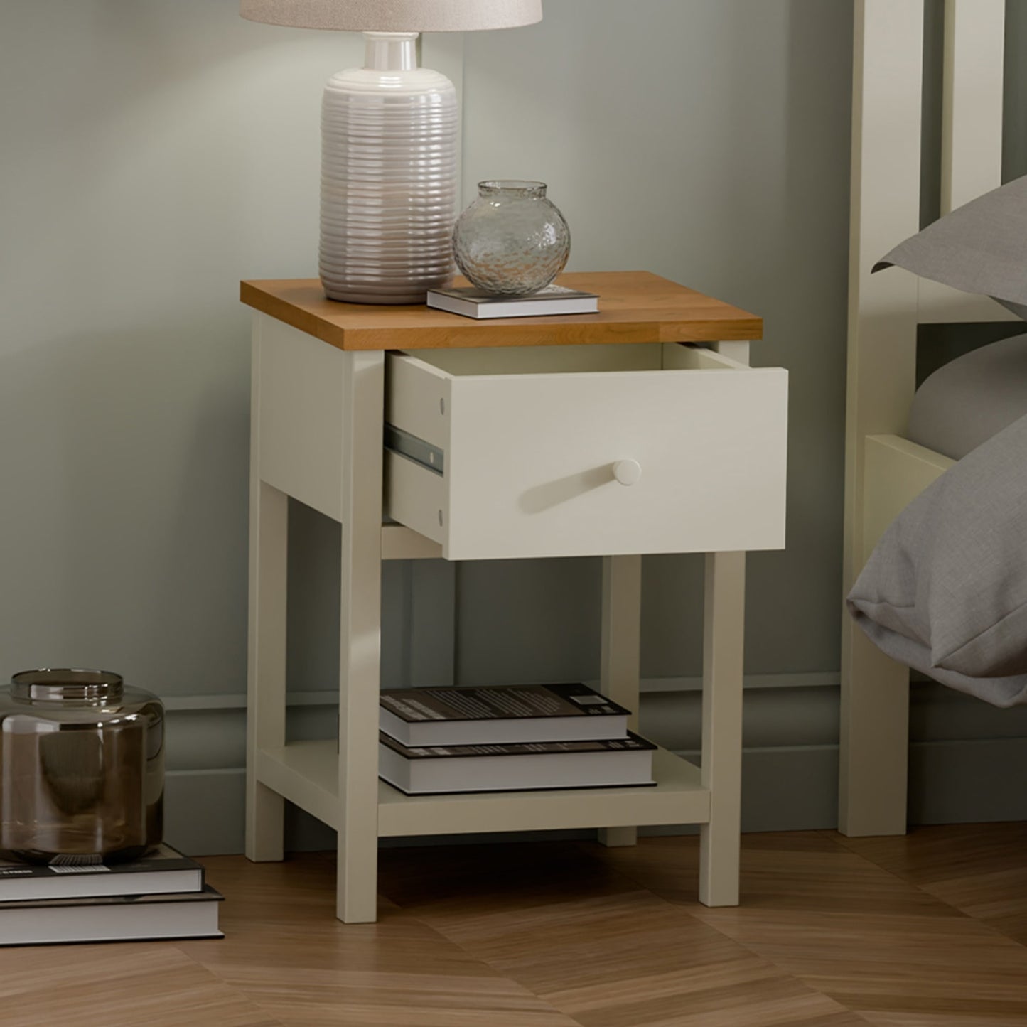 Close-up detail of the painted ivory drawer front, matching knob, and classic oak top surface.