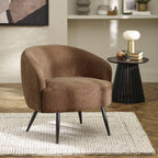 Dahlia curved barrel accent chair in rust brown textured faux linen fabric with black metal legs, styled in a modern living room