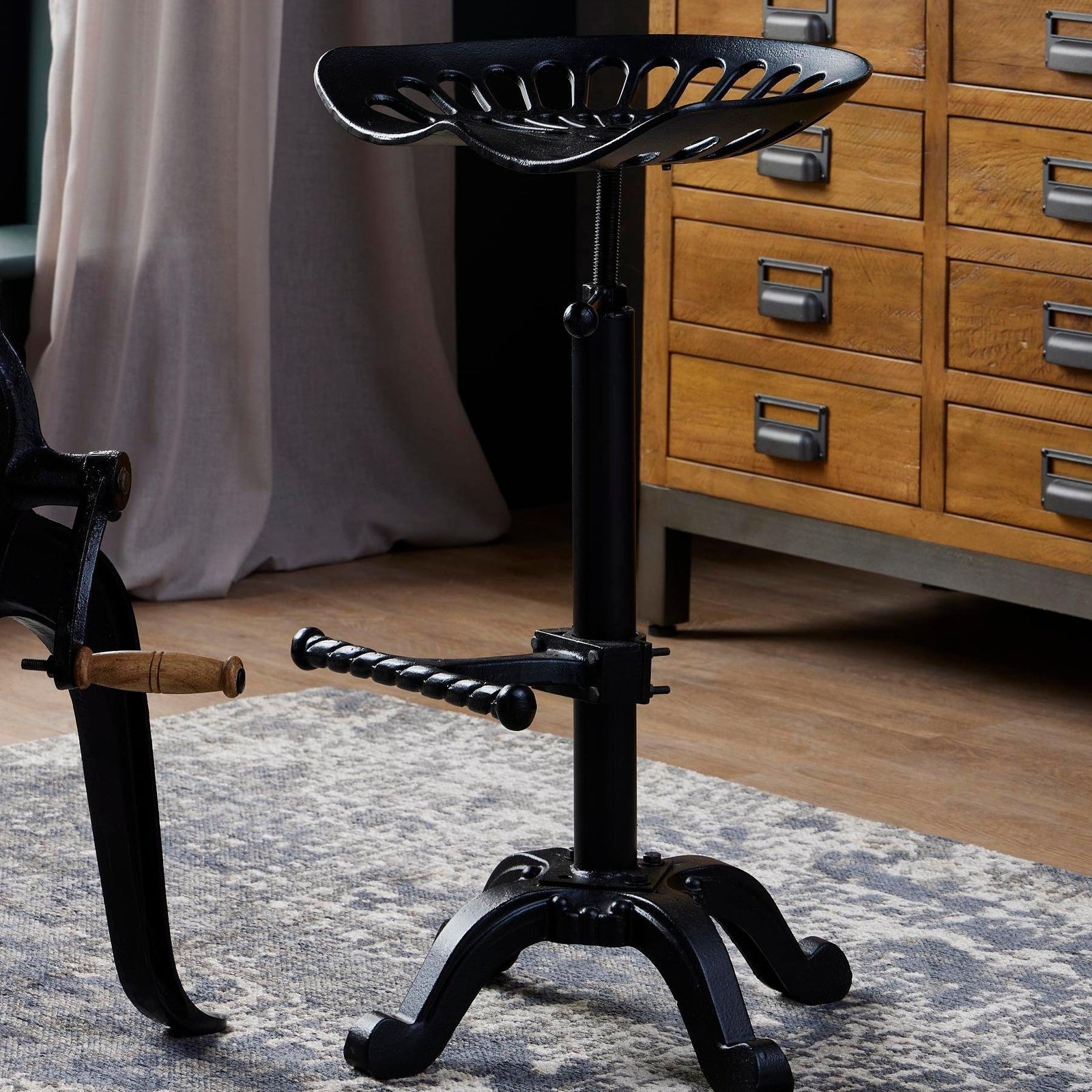 Draftsman adjustable tractor seat bar stool styled next to the matching bar table crank base