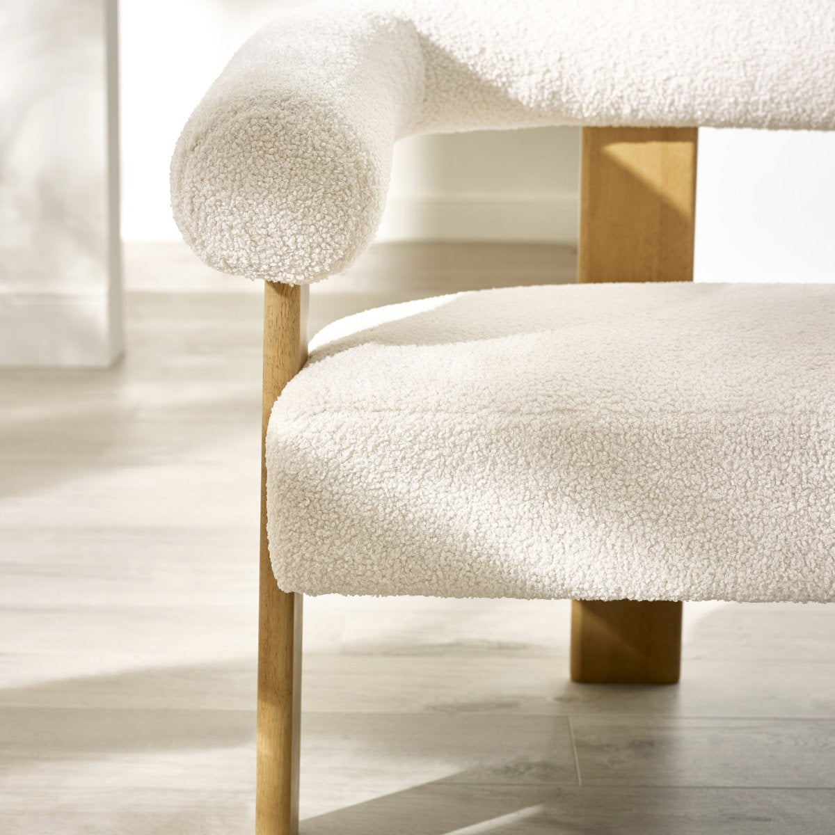Close-up detail of the durable neutral fabric and plush cushion showing termination of wooden frame on the armrest of the Freya sofa