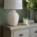 Close-up shot of the natural wooden top surface of the Haldon chest styled with a ceramic lamp and candle holder