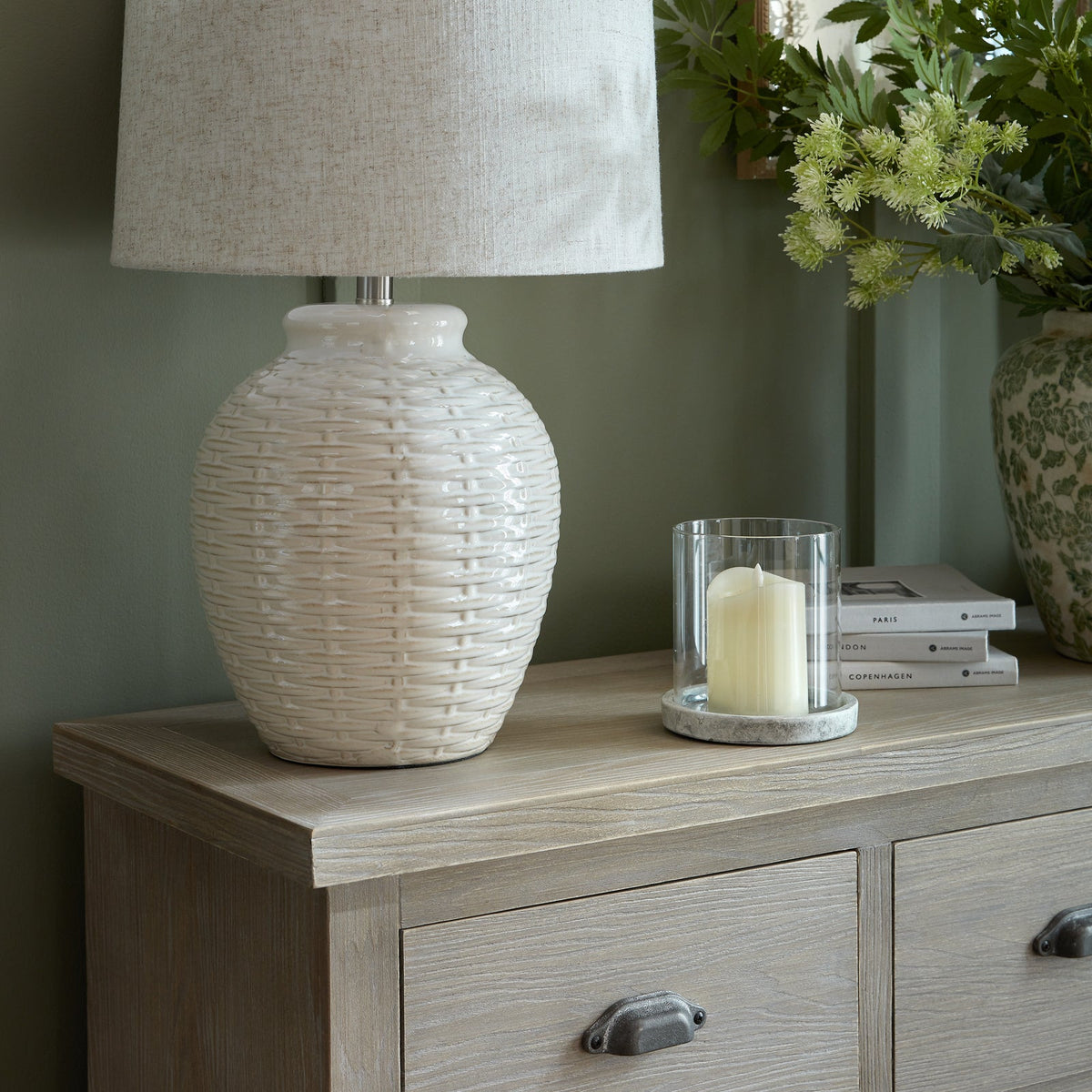 Close-up shot of the natural wooden top surface of the Haldon chest styled with a ceramic lamp and candle holder