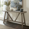 Haldon wooden trestle console table styled against a green wall with a ceramic vase, art print, and decorative jars