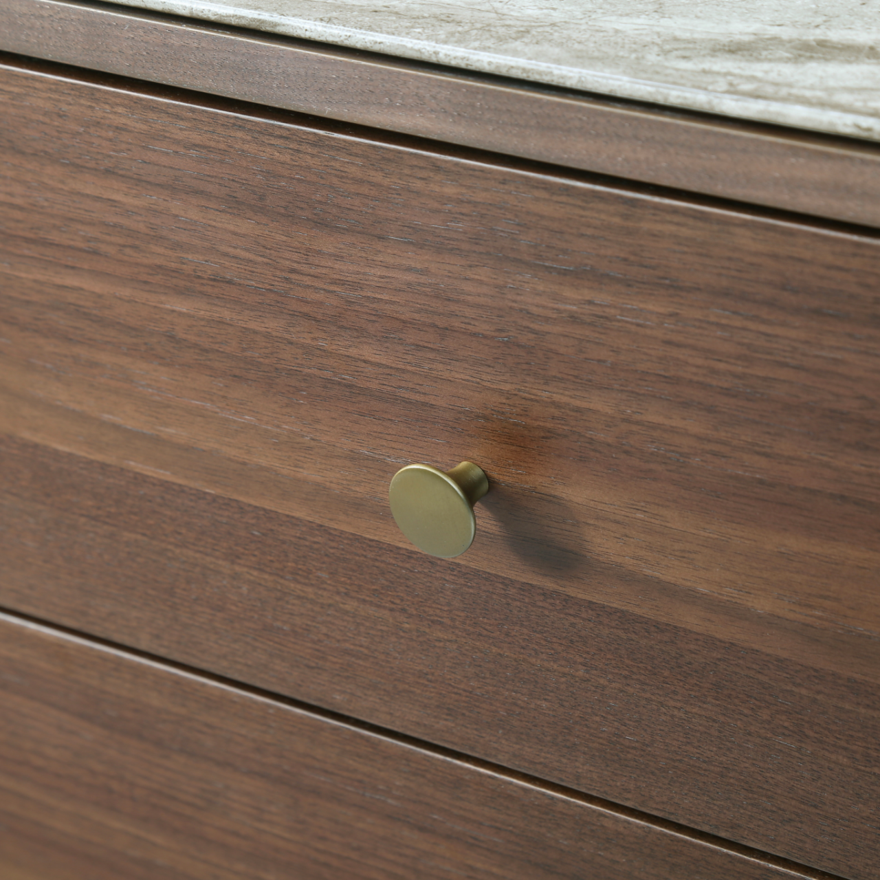 Brass pull hardware detail and black cylindrical leg base on the Isla tobacco walnut dresser