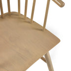 High angle studio view showcasing the smooth wood grain seat pan of the Kaito oak spindle dining chair
