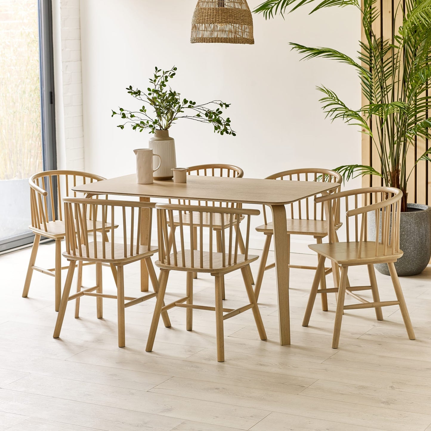 Kaito oak wooden spindle dining chairs arranged around a matching wooden dining table