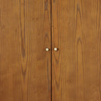 Direct front view studio shot of the closed double doors and gold hardware on the Lowry Cherry Ash wardrobe