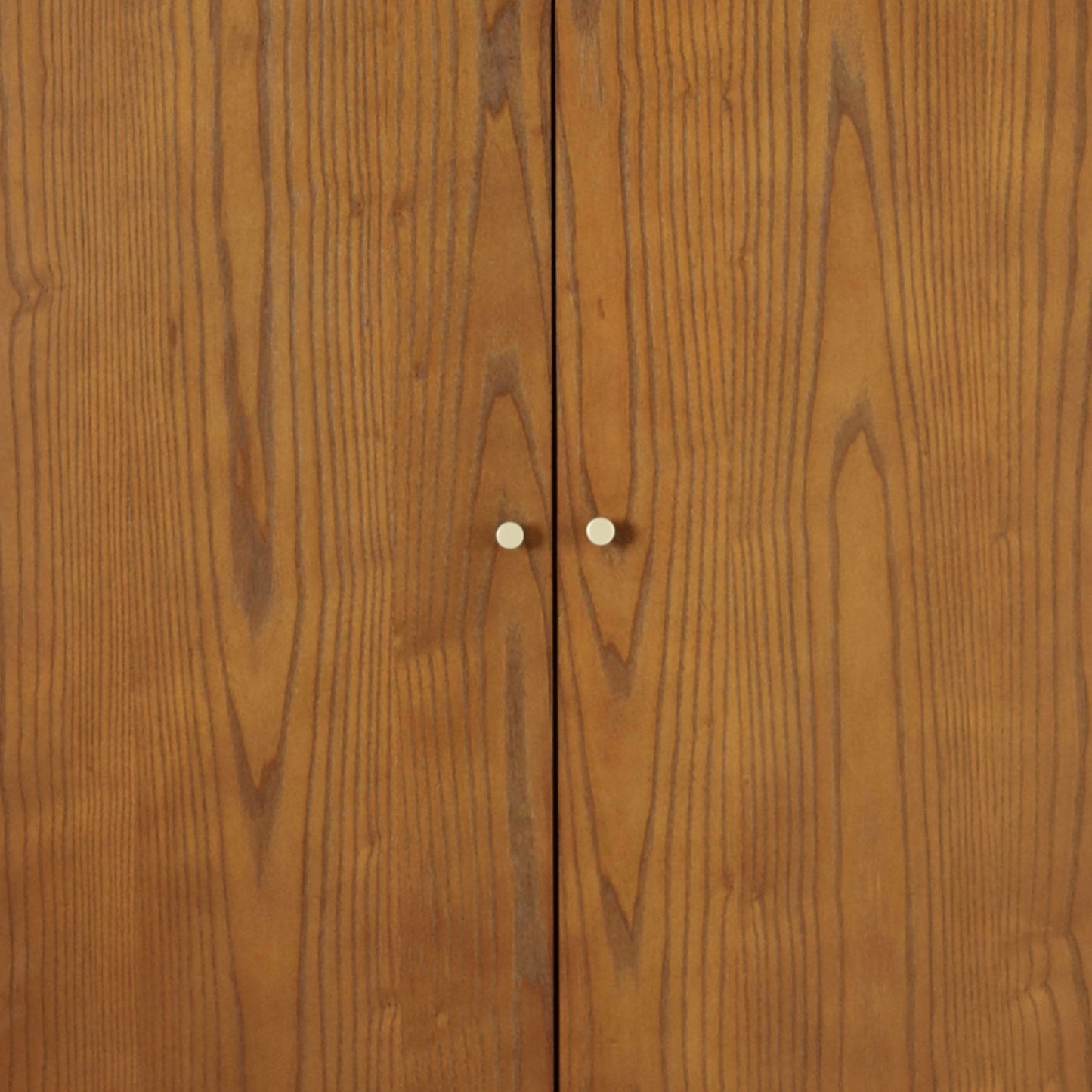 Direct front view studio shot of the closed double doors and gold hardware on the Lowry Cherry Ash wardrobe