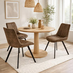 Malmo coffee brown faux leather swivel dining chairs styled around a round wooden dining table in a bright modern dining room