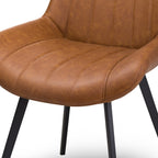 Close-up view of the vertical channel stitching and warm tan faux leather upholstery on the Malmo dining chair seat