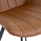 Close-up shot of the vertical channel stitching and warm tan faux leather upholstery on the Malmo swivel dining chair