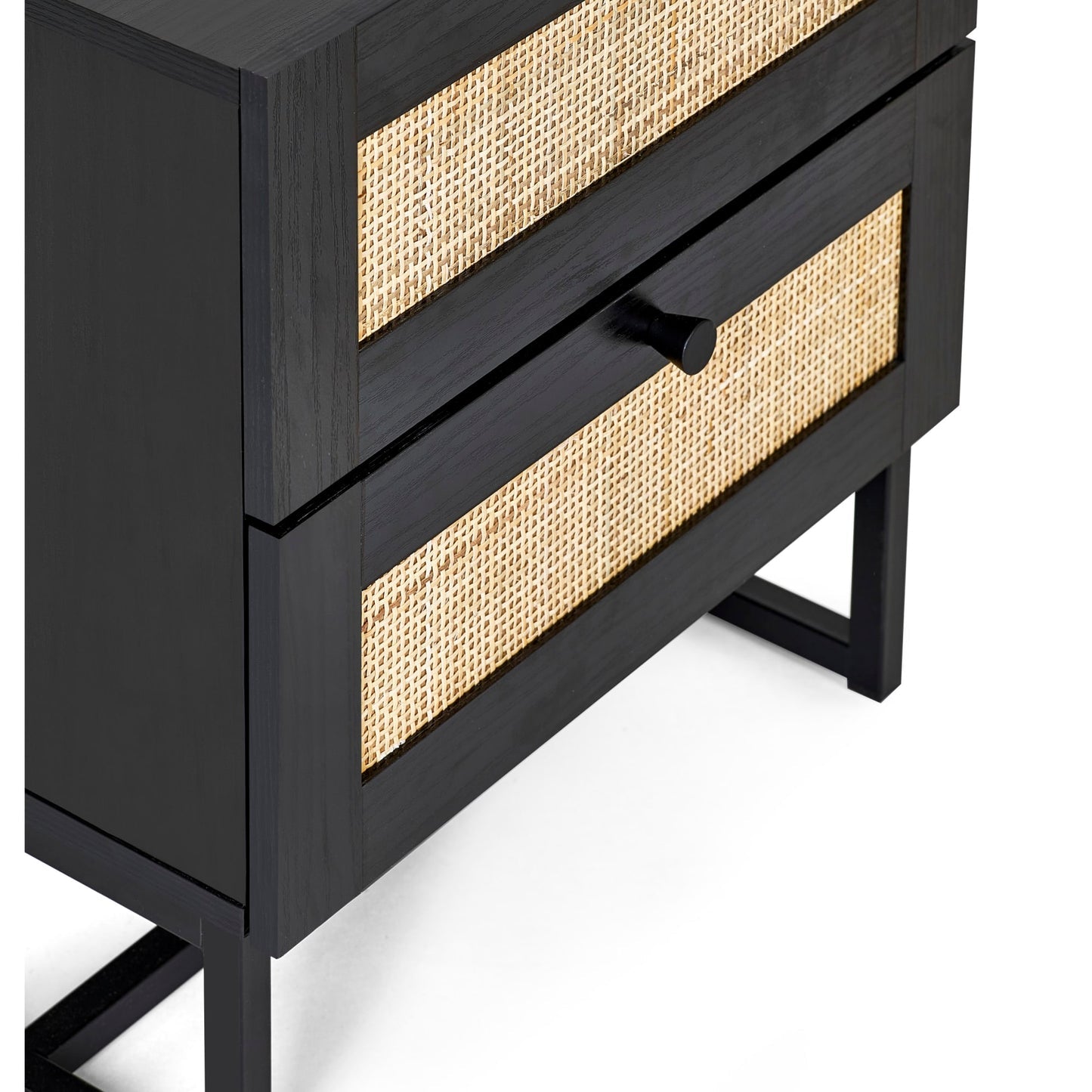 Close-up view of woven rattan cane panels and black metal frame on black oak bedside table