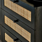 Close-up shot showing the woven cane rattan drawer details and black handles on the black oak chest